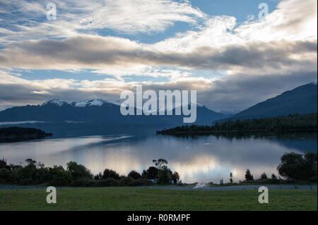 Wunderschöne Aussicht auf Lake Te Anau und die Murchison Berge von Te Anau Downs. Sonnenuntergang über dem See mit schönen rosa Wolke Reflexionen Stockfoto