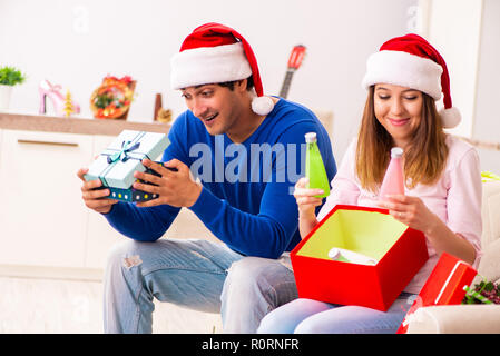 Junges Paar Weihnachten zu Hause feiern. Stockfoto