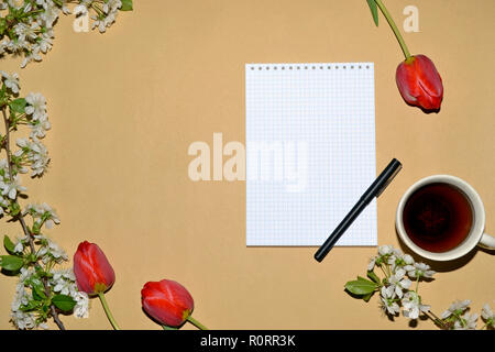 Öffnen Sie den Editor für das Schreiben mit Tulpen und weißen Blumen eingerahmt, und eine Tasse Kaffee. Stockfoto