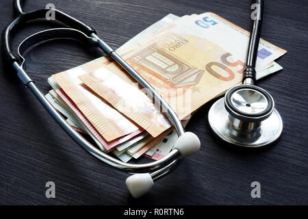 Stethoskop und Euro-banknoten auf einem Schreibtisch. Krankenversicherung und die Kosten für die Medizin. Stockfoto