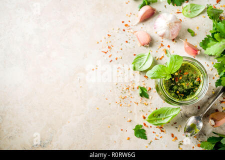 Argentinische traditionelles Essen, raw Hausgemachte grüne Salsa oder Chimichurri Sauce mit Petersilie, Knoblauch, Basilikum, Pfeffer und Gewürze, Licht Stein, Registerkarte Stockfoto