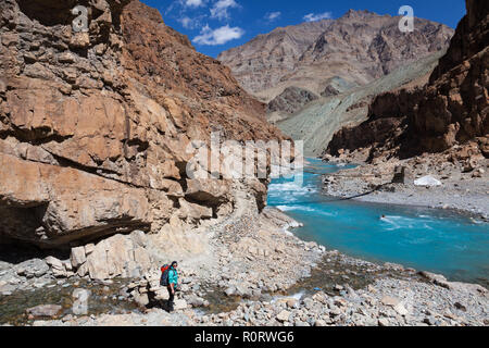 Einsame weibliche Trekker auf dem Weg zur Phugtal Gompa nahe der Brücke über Tsarap River (auch als Tsarab Chu bekannt), Zanskar, Indien Stockfoto