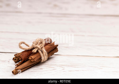 Cinnamon Sticks mit Jute Seil auf whtie Holz- Hintergrund gebunden Stockfoto