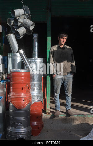 Junger Mann Aufwärmen in der Sonne verkaufen Heizungen in Mazar-e Sharif zentralen Basar, maraz-e Sharif, Provinz Balkh, Afghanistan Stockfoto