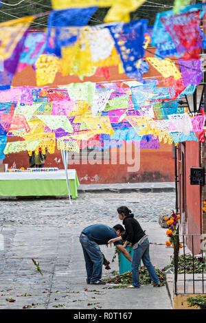 Mexikanische Familien ringelblume Blumen entlang der Straße mit Papel picado Banner in der Vorbereitung für einen Toten der Toten Prozession während der Dia de Muertos Festival in San Miguel de Allende, Mexiko eingerichtet. Das mehrtägige Festival ist daran zu erinnern, Freunde und Familienmitglieder, die gestorben sind, über calaveras, aztec Ringelblumen, alfeniques, papel Picado und die bevorzugten Nahrungsmittel und Getränke der Verstorbenen. Stockfoto