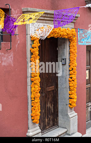 Eine Tür zu einem Haus mit Ringelblume Blumen der Toten home während der Dia de Muertos Festival in San Miguel de Allende, Mexiko begrüßen zu dürfen. Das mehrtägige Festival ist daran zu erinnern, Freunde und Familienmitglieder, die gestorben sind, über calaveras, aztec Ringelblumen, alfeniques, papel Picado und die bevorzugten Nahrungsmittel und Getränke der Verstorbenen. Stockfoto