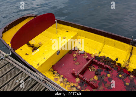 Eine bunte Punt oder vergnügen Ruderboot auf dem Chichester Ship Canal voll mit farbigen Blätter im Herbst, die in das Boot im Herbst gefallen sind. Stockfoto