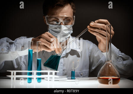 Junge Wissenschaftler mit auto-Pipette mit Kolben in der medizinischen Wissenschaft Labor. Forscher Konzept. Stockfoto