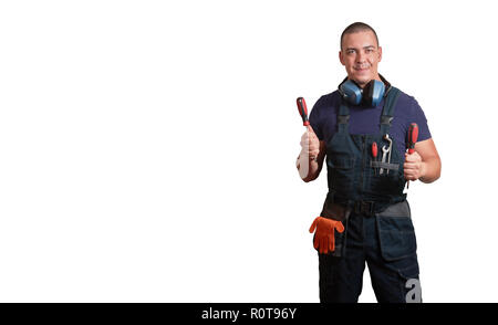 Starke männliche Mechaniker in Blau overal stehend mit orange Handschuhe, weißen Helm, Gehörschutz und Tools auf einem weißen Hintergrund isoliert Stockfoto