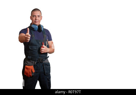 Starke männliche Mechaniker in Blau overal stehend mit orange Handschuhe, weißen Helm, Gehörschutz und Tools auf einem weißen Hintergrund isoliert Stockfoto