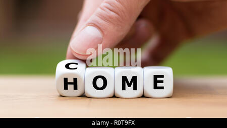 Hand dreht einen Würfel und Änderungen das Wort 'kommen' zu 'Home' Stockfoto