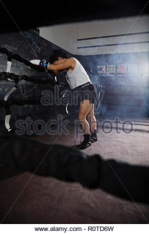 Müde weibliche Boxer ruht im Boxring