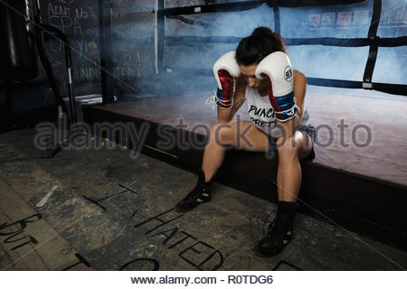 Müde weibliche Boxer in der Turnhalle ausruhen