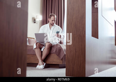 Geschäftsmann Gefühl besetzt während der Vorbereitung für das Treffen in seinem Hotelzimmer Stockfoto