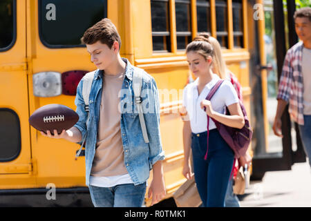 Gruppe von Happy Teen Schüler vor der Schule Bus Stockfoto