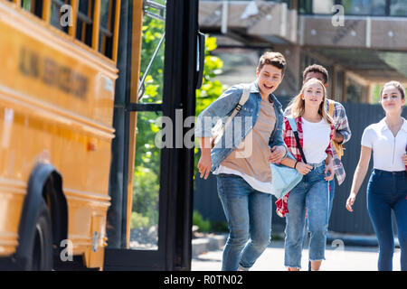 Gruppe von Happy Teen Gelehrten mit dem Bus zur Schule nach dem Unterricht nach Hause kommen Stockfoto