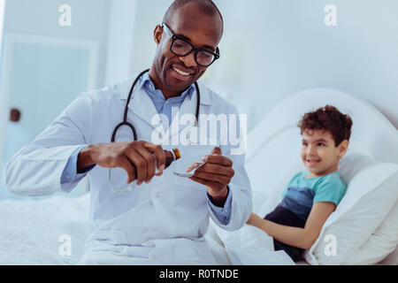 Positive smart Arzt gießen Mischung in den Löffel Stockfoto