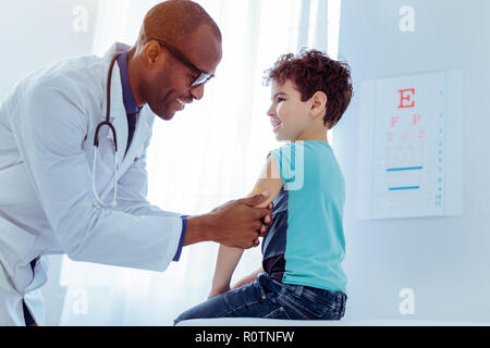 Positiv netter Mann, Pflaster auf Jungen arm Stockfoto