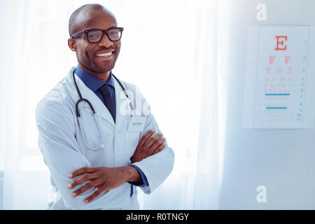 Freuen smart Arzt hohes Kreuz in seinem Krankenzimmer übergeben Stockfoto