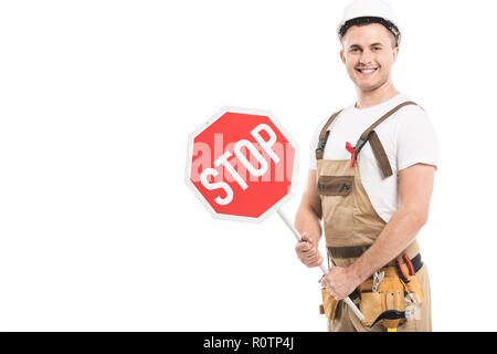 Lächelnd nach Builder mit aids awareness red ribbon auf die Holding Stop Schild und Kamera isoliert auf weißem Stockfoto