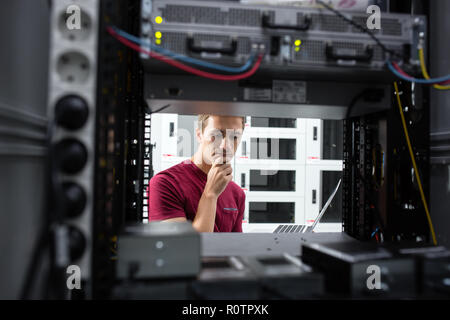 Männliche Server Techniker arbeitet auf einem Laptop in großen Rechenzentren. Stockfoto