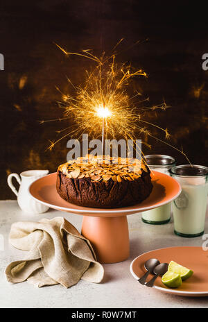 Glutenfreie und vegane Schokolade Mandel paleo Kuchen auf dem Tisch mit brennenden festliche Sparkler Stockfoto