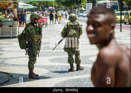 RIO DE JANEIRO - ca. Februar 2018: bewaffnete Soldaten in voller Uniform stand Guard am Strand von Copacabana, füllen eine Lücke durch einen Streik der Polizei links Stockfoto