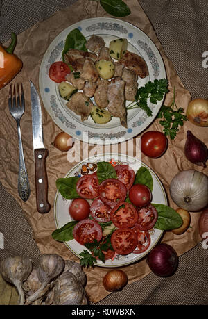 Fleisch und Kartoffeln und Tomaten Salat. Noch immer leben Ansicht von oben. Stockfoto