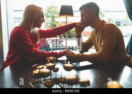 Mann küssen Frau Hand in Cafe Stockfoto