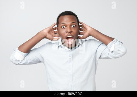 Portrait der Afrikanischen jungen gutaussehenden Mann überrascht mit Nachrichten, die er erhielt. Stockfoto