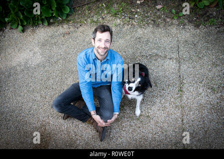 Porträt der Grafikdesigner Andreas Knapp, das mit seinem Hund Momo, ein Border Collie, in ein Stop in Lissabon, während Reisen durch Europa. Stockfoto