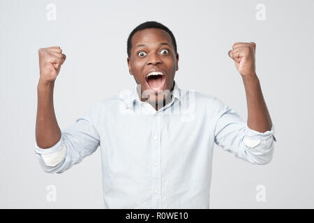 Portrait der Afrikanischen jungen gutaussehenden Mann überrascht mit Nachrichten, die er erhielt. Stockfoto