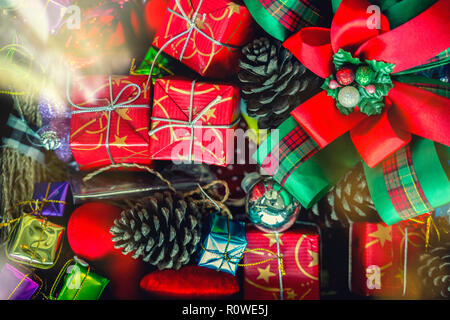 Frohe Weihnachten Urlaub Hintergrund Konzept. Nahaufnahme von roten Geschenkboxen dekoriert mit Zubehör auf dem Boden gestapelt. Stockfoto