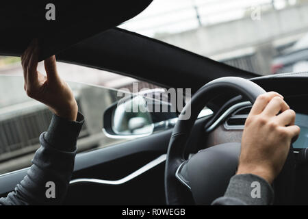 Mann Einstellen der Rückspiegel während der Fahrt ein Auto Stockfoto