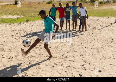Junge spielt Fußball im Boden Stockfoto