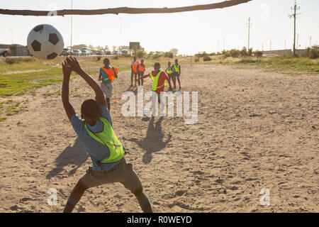 Kinder spielen Fußball im Boden Stockfoto