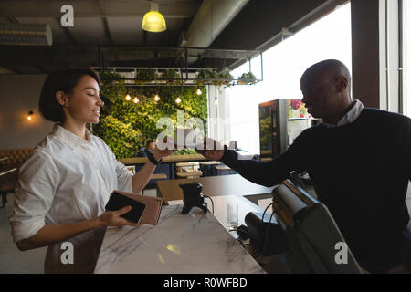 Kellner servieren Kaffee zu weiblichen Executive am Zähler Stockfoto