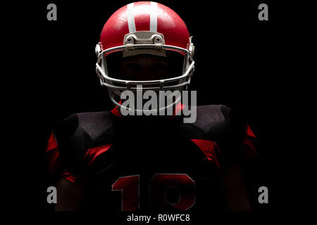 American football player stehend mit Rugby Helm Stockfoto