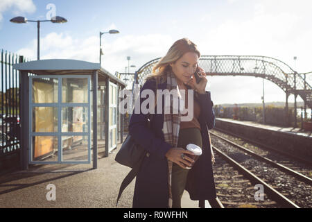 Schwangere Frau Gespräch am Handy in der Plattform Stockfoto