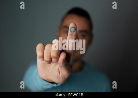 Nahaufnahme eines jungen kaukasischen Mann mit einem blauen Kreis, das Symbol des Diabetes, in seinen Zeigefinger, zur Unterstützung dieser Krankheit Stockfoto