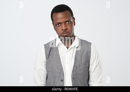 Afrikanischer Mann blies seine Backen, während jemand, der seine negative Emotion beleidigt wird, Stockfoto