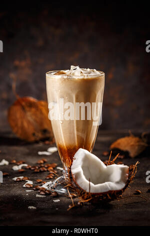 Kaffee mit Kokosmilch auf dunklem Hintergrund Stockfoto