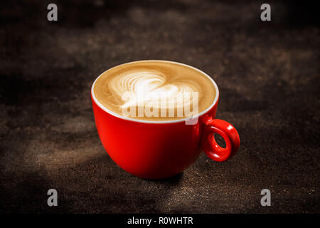 Tasse Kaffee mit Herzform Dekoration auf dunklem Hintergrund Stockfoto