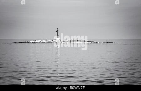 Rundumleuchte auf der kleinen Insel in der Nähe der Küste, Porec, Kroatien. Sicherheit im Seeverkehr. Schwarz-weiß Foto. Stockfoto