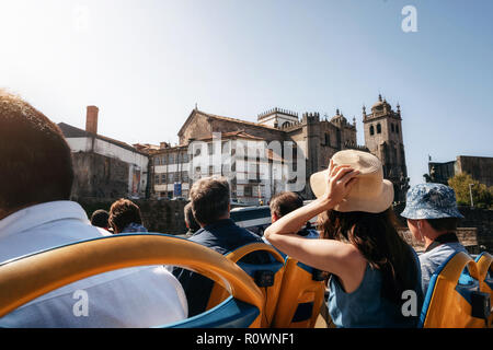 Porto, Portugal. Touristen auf Open top Sightseeing Bus Hop-on-Hop-off in der Stadt zu erkunden. Kathedrale Seu auf dem Hintergrund Stockfoto