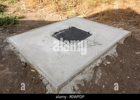 Die Klappe auf eine Grube für eine Jauchegrube. Kanalisation Bau. Stockfoto