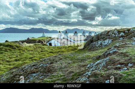 Eine Ansicht von hohen Boden über den Piloten Hütten auf llanddwyn Island, Anglesey, UK. Die Berge von Snowdonia im Hintergrund. Am 1. November. Stockfoto