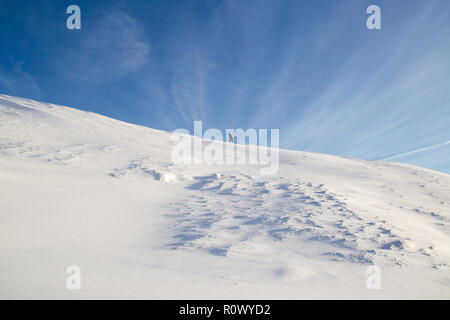 Einsamer Wanderer klettert auf White Snow Ridge Berg im Winter in ein Ziel ideal für Bergwandern und Wintersport in Island Stockfoto