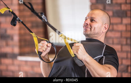 Starker, muskulöser Mann Trainieren mit trx Einrichtungen im Fitnessraum oder Training Center. Stockfoto