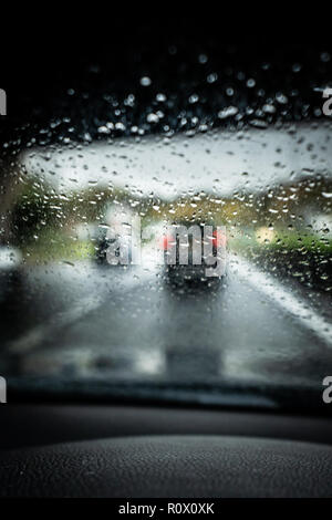 Regen auf der Autobahn, starker Regen auf der Frontscheibe, der Windschutzscheibe während der Fahrt auf der Autobahn im Auto, Van, Lkw, gefährlichen Fahrbedingungen. Stockfoto